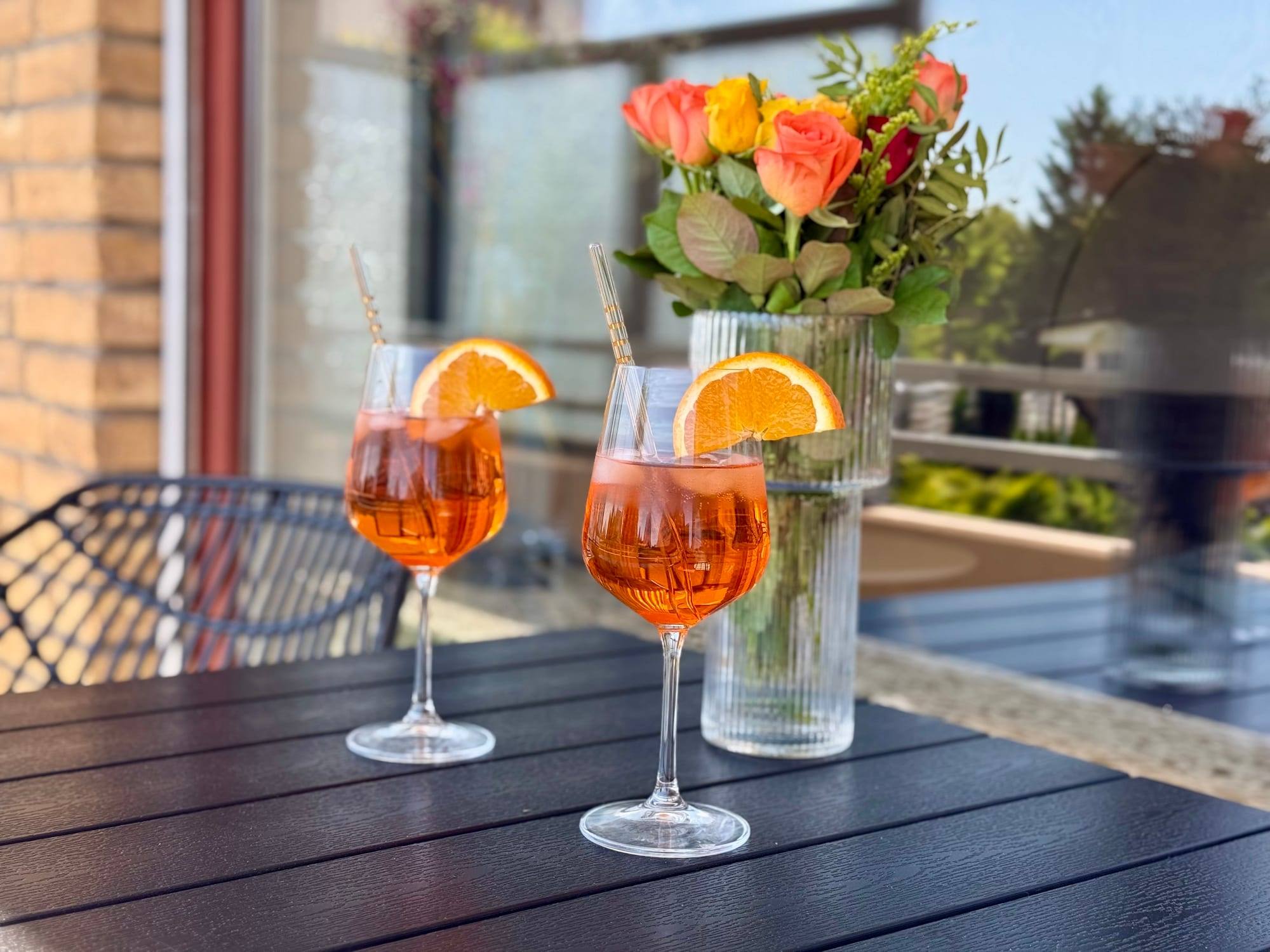 Two drinks and flowers on the balcony table