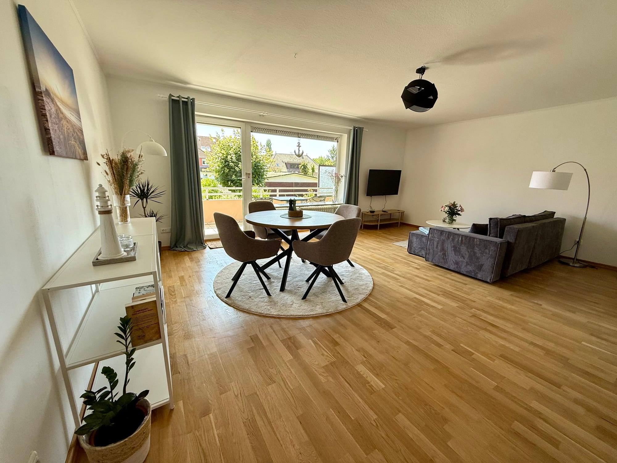 Bright living room with dining table, sofa corner and access to the balcony